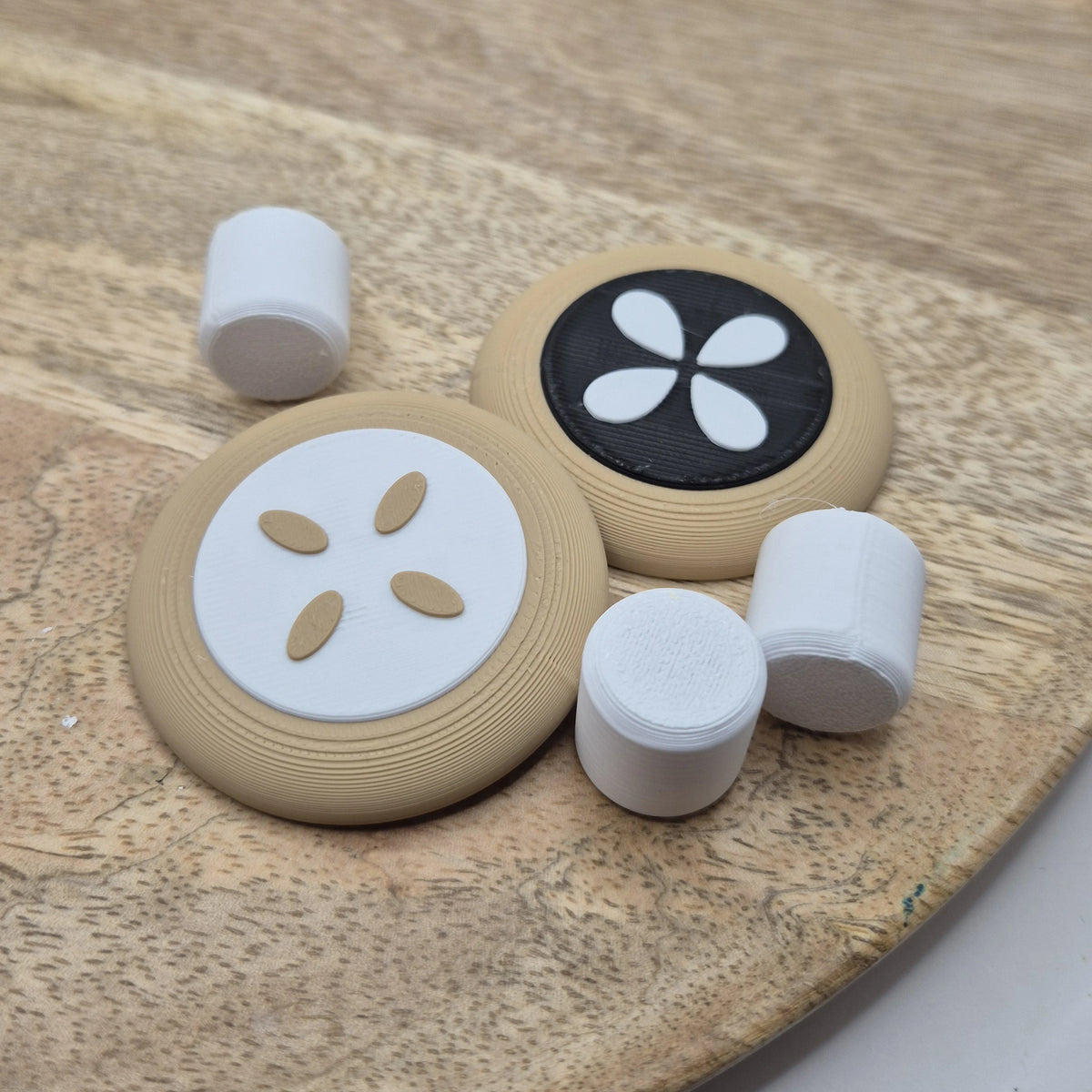 Dva 3D tlačené koláčiky a biele marshmallow zblízka na drevenom podnose