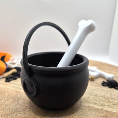 Čierny 3D tlačený kotlík s uchom a biela naberačka v tvare kosti